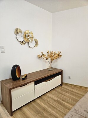 A modern room with a wooden console table, white drawers, and decorative wall art. - Malta View Prestige (Poznań)