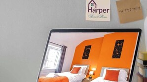 Ein Laptop, der einen Hotelraum mit zwei Betten, einem Fenster und einem Schild mit dem Namen des Hotels zeigt.