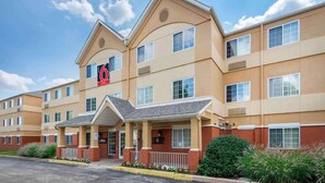 Ein mehrstöckiges Hotel mit beiger Fassade, einem gut sichtbaren '6' Schriftzug und einem überdachten Eingang.