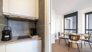 Een moderne keuken met een koffiezetapparaat, een notitieboekje en een tablet op het aanrecht.