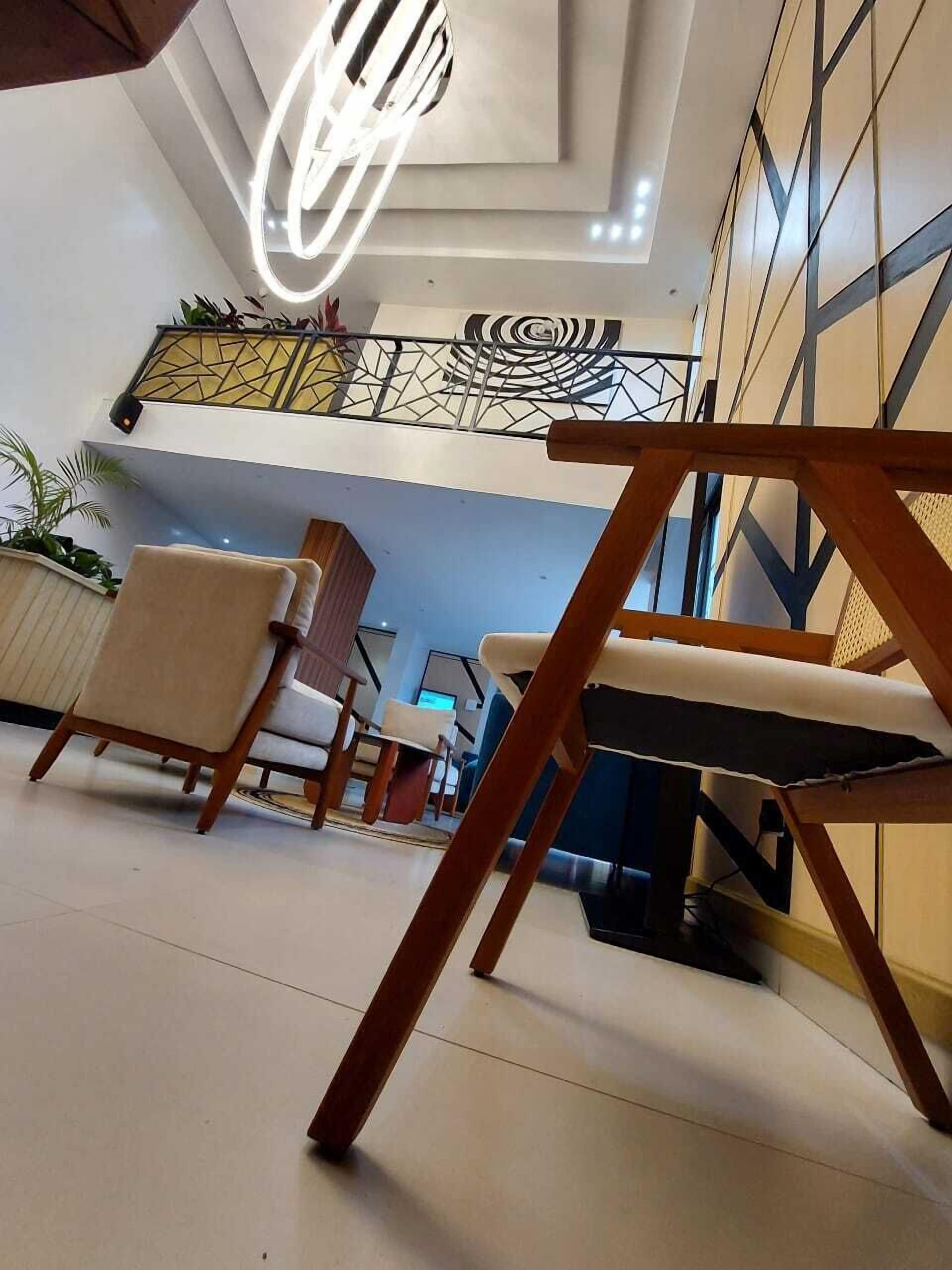 A modern interior with a seating area, a staircase, and a decorative ceiling light.