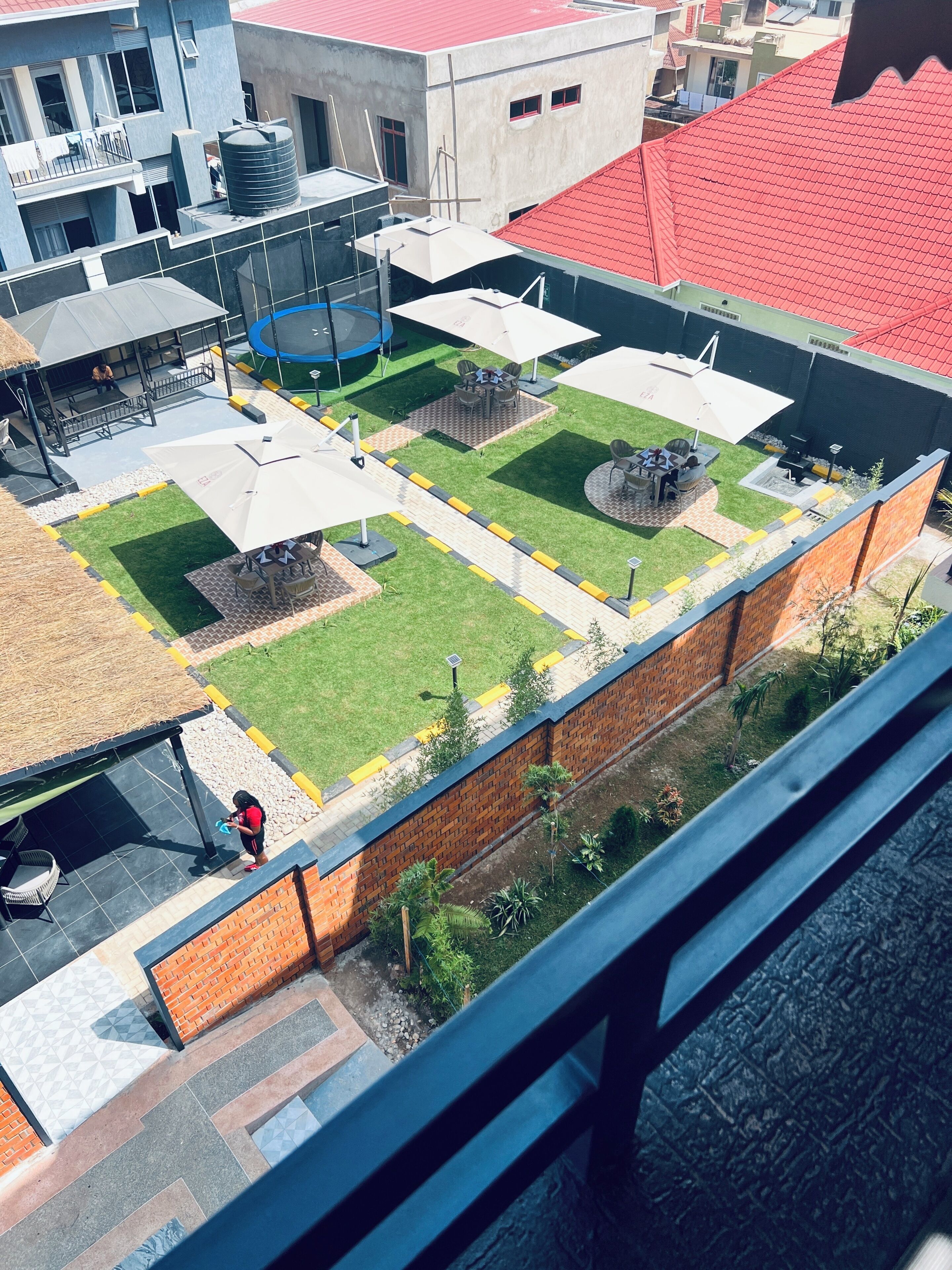 Una terraza en la azotea con un pequeño jardín, zonas de estar y un depósito de agua.