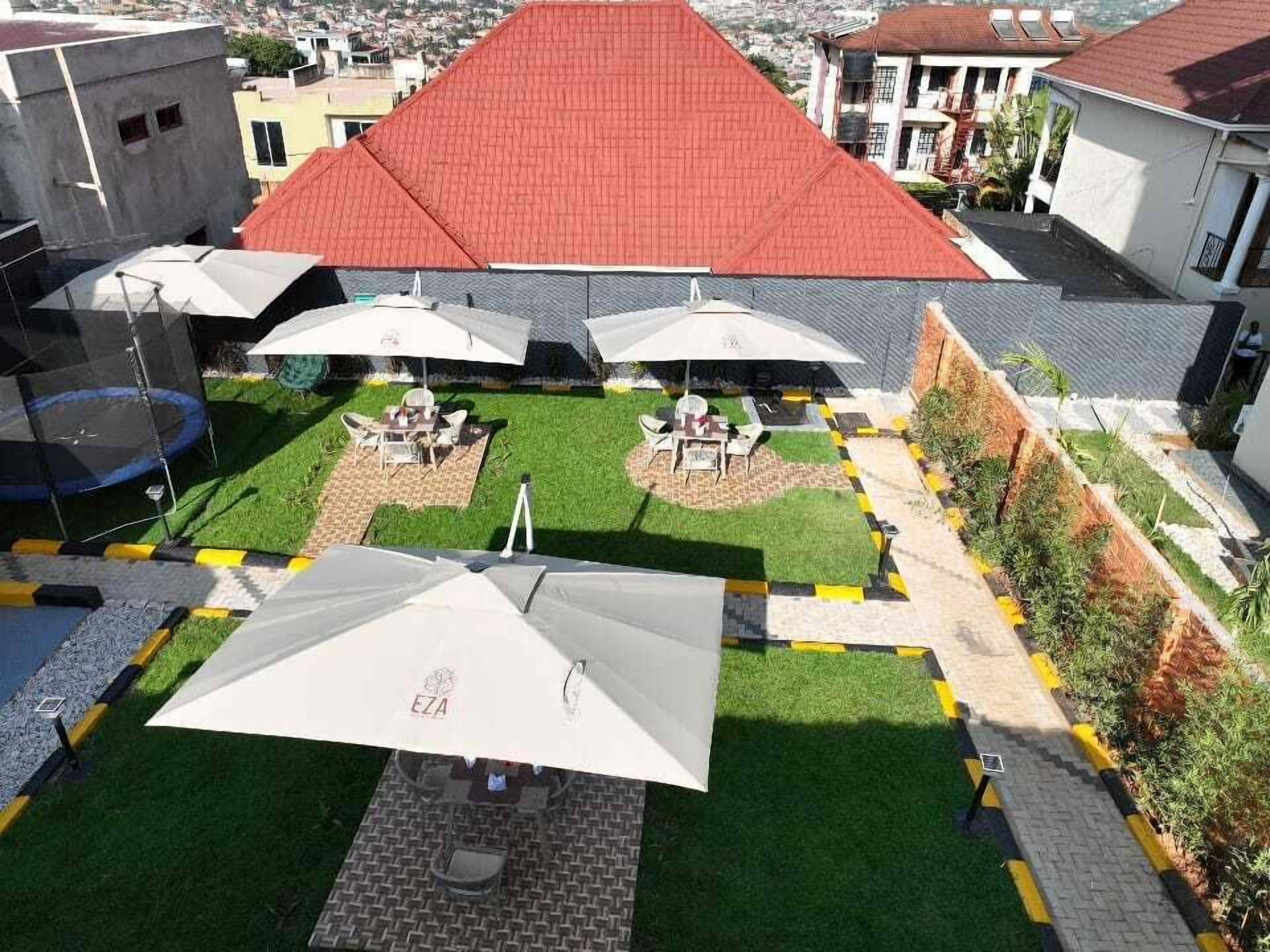 A rooftop patio with outdoor seating and umbrellas, surrounded by buildings.