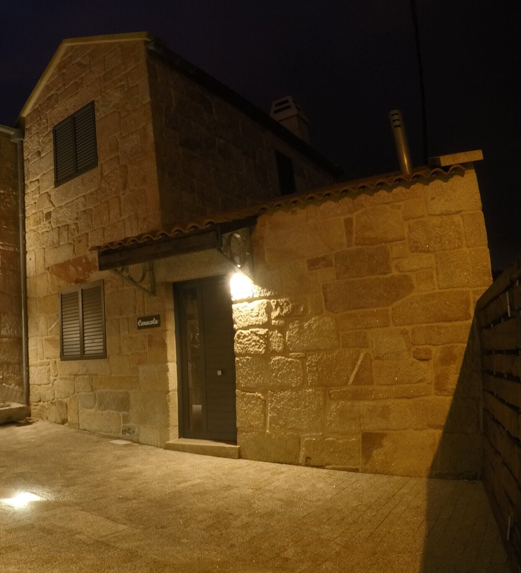 Un edificio de piedra con una entrada oscura y un letrero iluminado sobre la puerta.