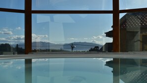 A swimming pool with a clear view of mountains and a building in the background. - Casa Rustica O Facho (Cangas)