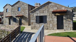 A stone building with a tiled roof, a door, and a window. - Casa Rustica O Facho (Cangas)
