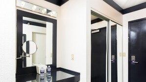 Une salle de bain avec un miroir, un meuble-lavabo et deux bouteilles d’eau.