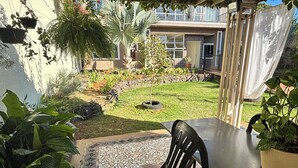 A patio area with a tiled floor, a table, and chairs. - Ravello Residential AP03 Foz do Iguaçu (Foz do Iguaçu)