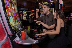 A casino environment with slot machines, a bar area, and a person playing a game.