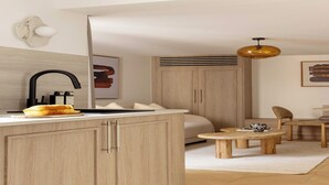 A modern hotel room with a wooden cabinet, a sink, a bed, a small table, and a hanging light fixture. - Modern Apartment a/c 1BR/2P - Saint-Germain (Paris)