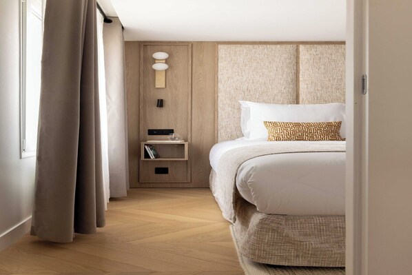 Ein Hotelzimmer mit Bett, Nachttisch und Wandlampe.
