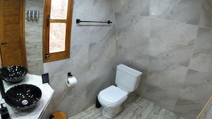 Une salle de bain avec des toilettes, un bidet et un lavabo noir.