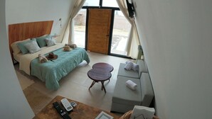 Une chambre à coucher avec un lit, un canapé, une table basse et un téléviseur.