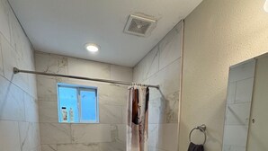A bathroom with a shower, toilet, sink, and a window. - Cozy 1-bedroom apartment in enjoyable Houston with AC (Houston)