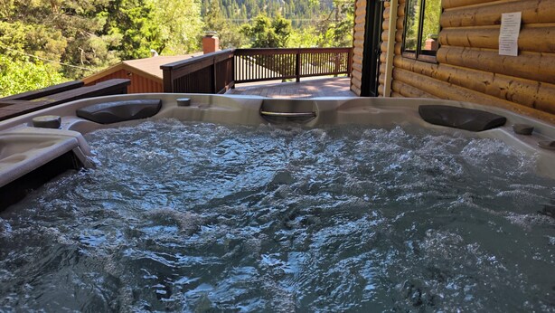 A hot tub with a wooden deck and a mountain view. - Mountain Home in Gallatin Canyon with Home Theater and 3 Spacious BR/BA (Gallatin Gateway)