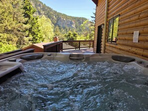 Ein Whirlpool mit Holzterrasse und Bergblick.