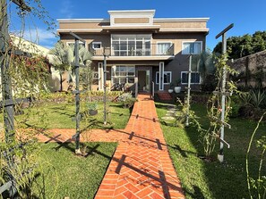A modern two-story house with a brick pathway leading to the entrance. - Ravello Residential AP04 Foz do Iguaçu (Foz do Iguaçu)