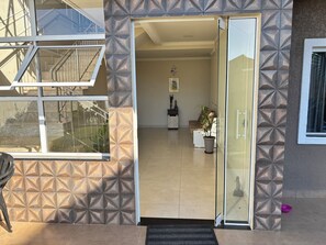 A hotel entrance with a glass door, a staircase, and a patterned wall. - Ravello Residential AP04 Foz do Iguaçu (Foz do Iguaçu)