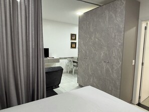 A bedroom with a bed, a desk, a chair, and a wardrobe. - Ravello Residencial – Comfort and tranquility in Foz do Iguaçu (Foz do Iguaçu)
