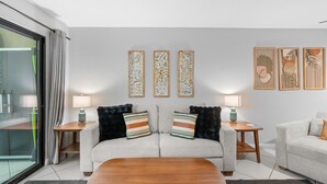 A modern living room with a sofa, two side tables, a coffee table, and three wall-mounted artworks. - Royal Kahili B204 AC Across From Lymans/banyans (Kailua-Kona)