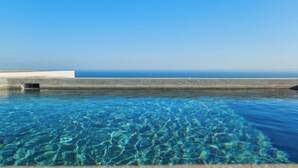 Una piscina cristalina con vista al océano.