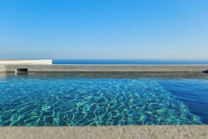 Une piscine aux eaux cristallines offrant une vue sur l’océan.