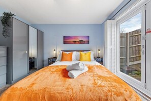 A hotel room with a bed, a painting, a window, and a plant. - 1BR • Free Parking • Home Away From Home • LGW (Crawley)