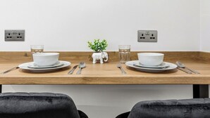 A dining table with two white bowls, two glasses, and a small elephant-shaped vase. - 2BR • New Listing Discount • Free Parking (West Sussex)