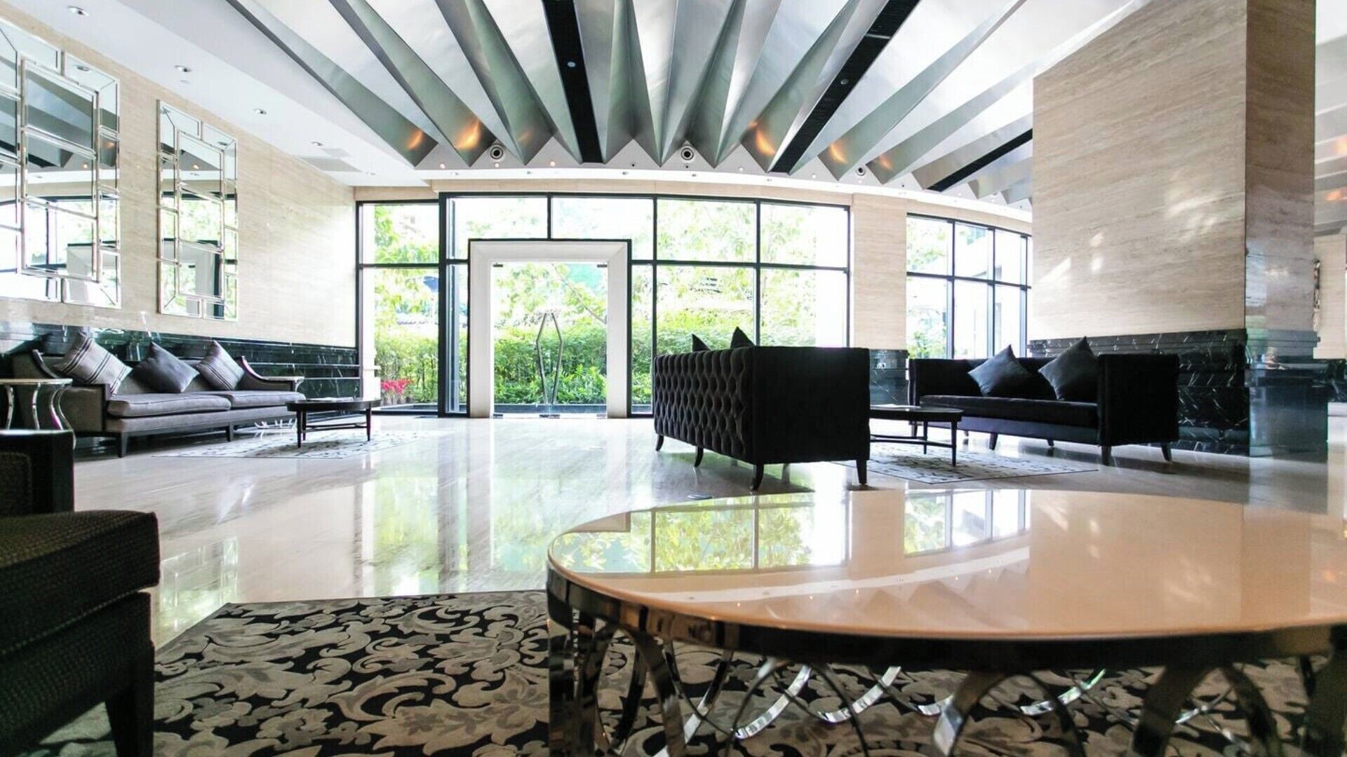 A spacious lobby with a curved seating area, large windows, and a modern ceiling design.