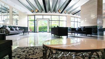 A spacious lobby with a curved seating area, large windows, and a modern ceiling design.