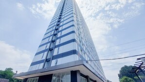 Ein hohes, modernes Gebäude mit Glasfassade und einem markanten, vertikalen Designelement.