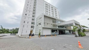 Un bâtiment moderne à plusieurs étages, doté d’une façade sobre, de grandes fenêtres et d’un espace d’entrée abrité.