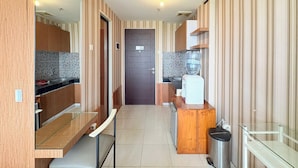 Una cocina moderna con armarios de madera, una encimera, un dispensador de agua y un cubo de basura.