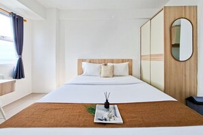 Una habitación de hotel con una cama, cabecera de madera, un espejo y una ventana con cortinas.
