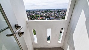 A balcony with a metal handrail and a view of a residential area. - Cozy Studio Apartment At Urbantown Serpong (South Tangerang)