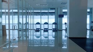 A modern fitness center with glass walls, a reflective floor, and treadmills aligned in the center. - Cozy Living 2Br Apartment At Green Bay Condominium (Jakarta)
