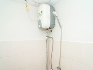 A corner shower with a handheld showerhead, a wall-mounted control panel, and a flexible hose. - Neat Studio Apartment At Green Palm Residence (Jakarta)