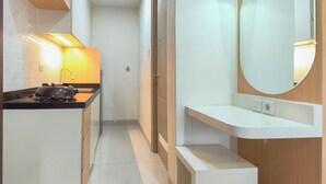 A modern kitchen with a stove, a countertop, and a sink. - Comfy Modern Look Studio Room At Apartment Grand Dharmahusada Lagoon (Surabaya)