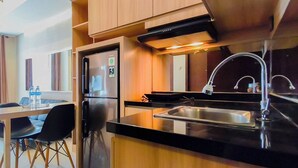 Una cocina compacta con refrigerador, estufa y lavaplatos.