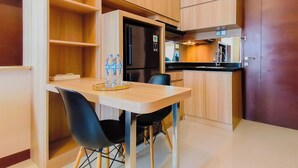 Una cocina compacta con una mesa de comedor, sillas y un refrigerador.