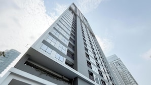 Un edificio alto con varios pisos, ventanas grandes y balcones.