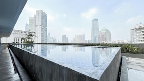Una piscina moderna en la azotea con vistas al horizonte de la ciudad.