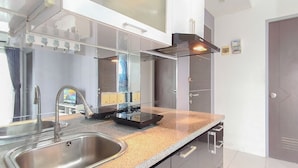 Una cocina moderna con un lavamanos de acero inoxidable, extractor de humos integrado y encimera de granito.