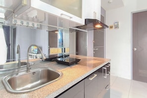 A modern kitchen with a stainless steel sink, a built-in range hood, and a granite countertop. - Spacious And Cozy 2Br At Tamansari Prospero Sidoarjo Apartment (Sidoarjo)