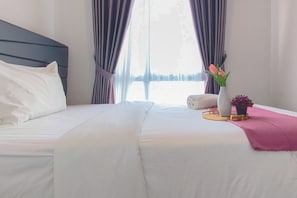 A neatly made bed with white linens, a dark headboard, and a pink throw blanket. - Spacious And Cozy 2Br At Tamansari Prospero Sidoarjo Apartment (Sidoarjo)