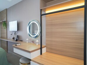 A modern bathroom with a vanity, mirror, and lighting. - Chic Brown Touch Studio At Apartment Collins Boulevard (Tangerang)