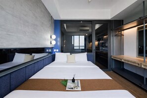 Una moderna camera d'albergo con un letto grande, comodini, vista attraverso una porta in vetro e un appendiabiti.