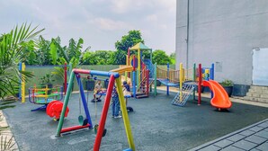A playground with various play structures including swings, slides, and climbing areas. - Classic Red Studio At Nifarro Park Apartment (Jakarta)