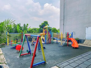 A playground with various play structures including swings, slides, and climbing areas. - Classic Studio Apartment At Nifarro Park (Jakarta)