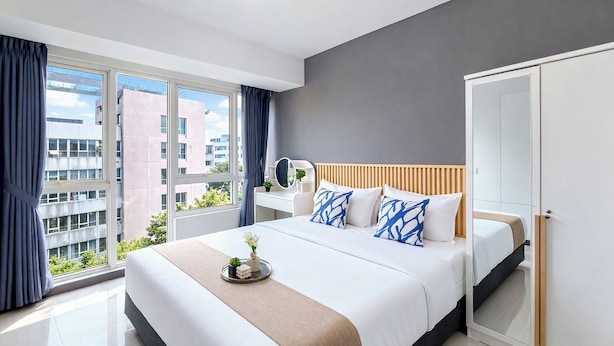 Ein modernes Schlafzimmer mit einem großen Bett, einem Nachttisch, einem Spiegel und einem Kleiderschrank.